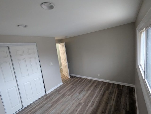 unfurnished bedroom featuring dark hardwood / wood-style flooring and a closet