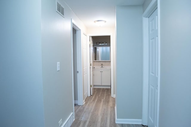 hall with sink and light hardwood / wood-style floors