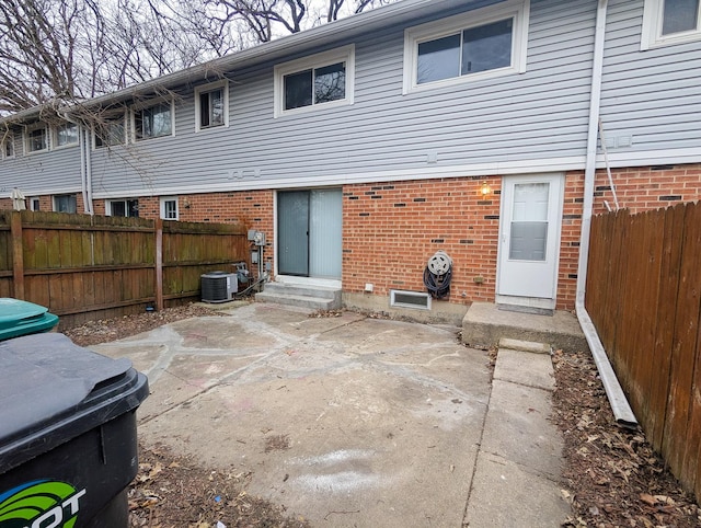 back of property with central AC and a patio area