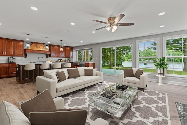 living room featuring ceiling fan and light wood-type flooring