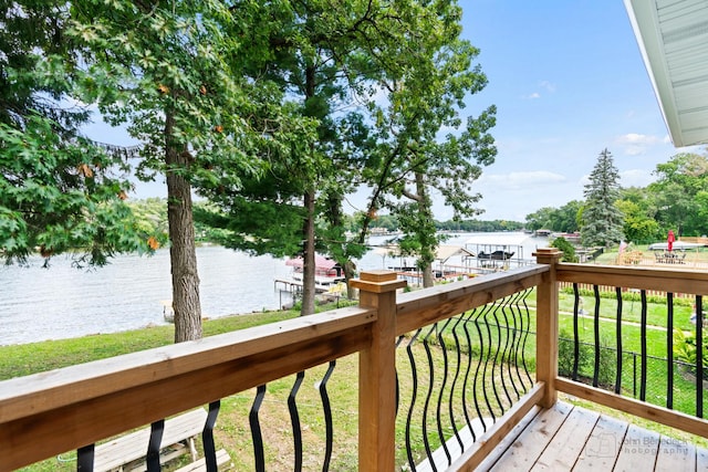 wooden terrace featuring a water view and a yard