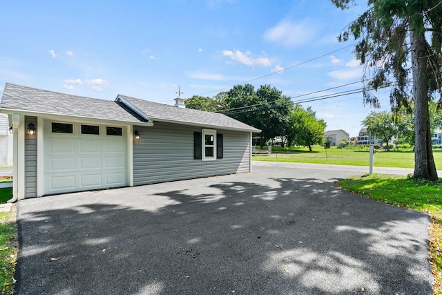 view of side of home featuring a yard and a garage