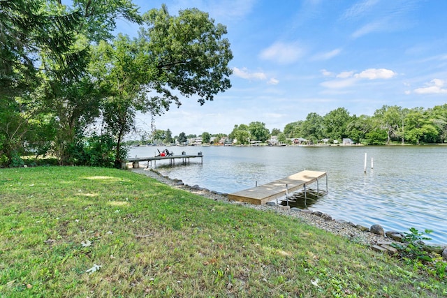 view of dock with a water view and a yard