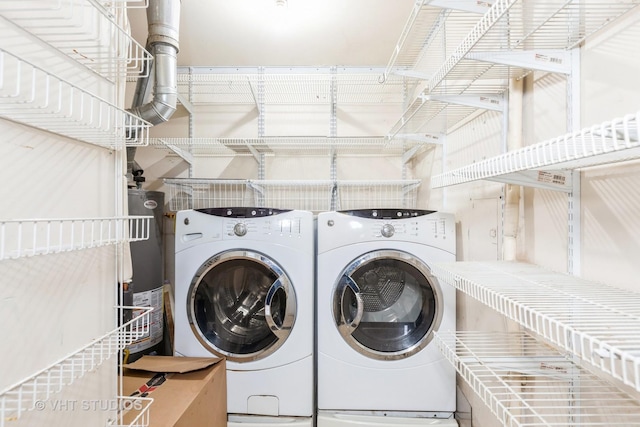 clothes washing area with water heater and washer and clothes dryer