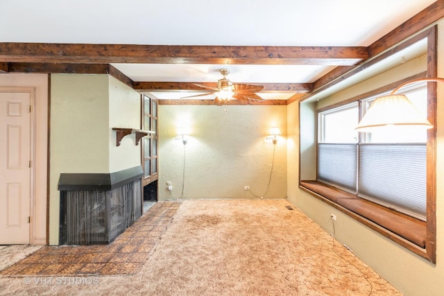 unfurnished living room featuring beam ceiling, ceiling fan, carpet, and a multi sided fireplace