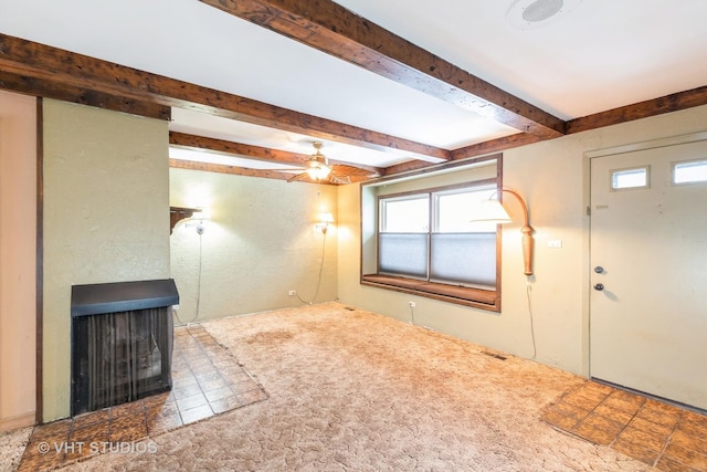 interior space featuring carpet flooring, ceiling fan, beamed ceiling, and a multi sided fireplace