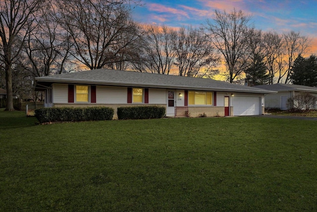 ranch-style house with a yard and a garage