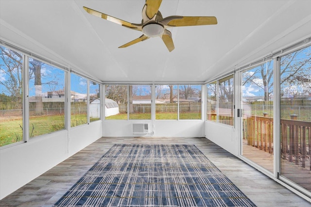 unfurnished sunroom with an AC wall unit and ceiling fan