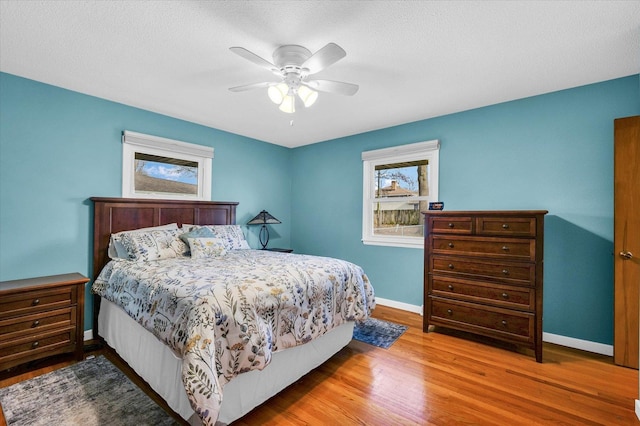 bedroom with hardwood / wood-style floors, a textured ceiling, and ceiling fan