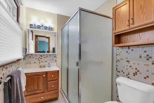 bathroom with decorative backsplash, vanity, an enclosed shower, and toilet