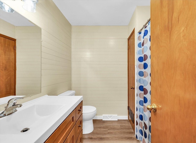 bathroom with hardwood / wood-style floors, vanity, and toilet