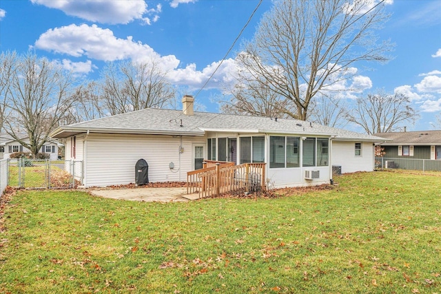 rear view of house featuring a sunroom, a yard, and a patio