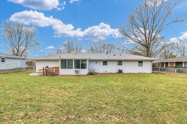 rear view of property with a lawn, a sunroom, and central AC unit