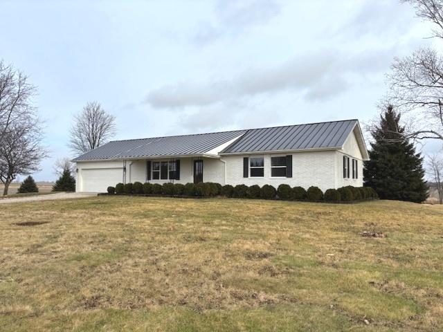 ranch-style home with a garage and a front lawn