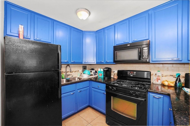 kitchen featuring dark stone counters, sink, blue cabinetry, black appliances, and light tile patterned flooring