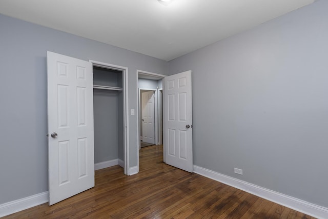 unfurnished bedroom featuring a closet and dark hardwood / wood-style flooring