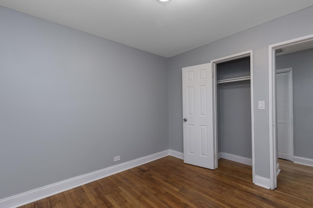 unfurnished bedroom with dark hardwood / wood-style flooring