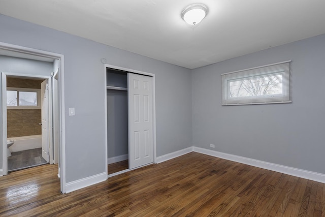 unfurnished bedroom with dark hardwood / wood-style flooring, connected bathroom, and a closet