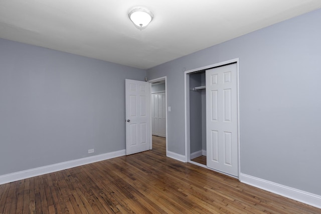 unfurnished bedroom with a closet and dark hardwood / wood-style flooring