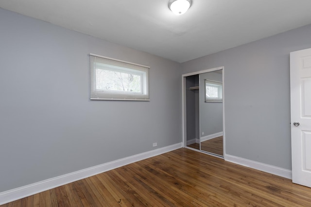 unfurnished bedroom featuring a closet and dark hardwood / wood-style floors