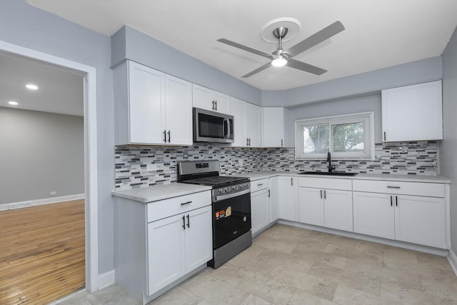 kitchen featuring white cabinets, backsplash, sink, and appliances with stainless steel finishes