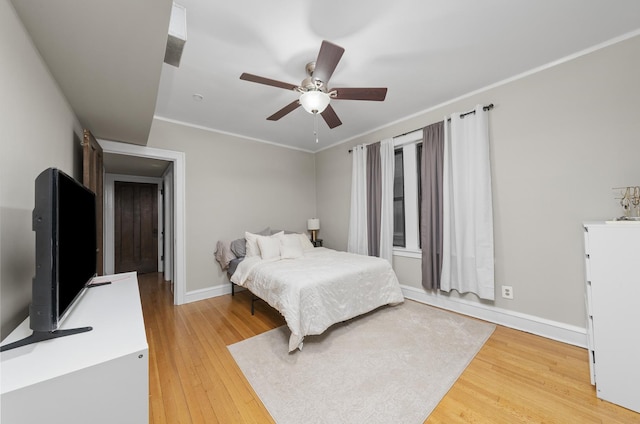 bedroom with ceiling fan, wood-type flooring, and crown molding