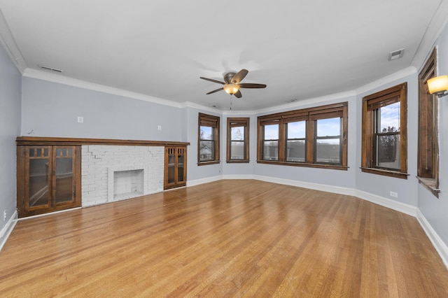 unfurnished living room featuring ceiling fan, a fireplace, light hardwood / wood-style floors, and ornamental molding