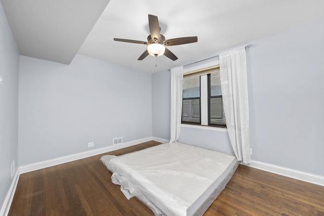 unfurnished bedroom featuring ceiling fan and dark wood-type flooring