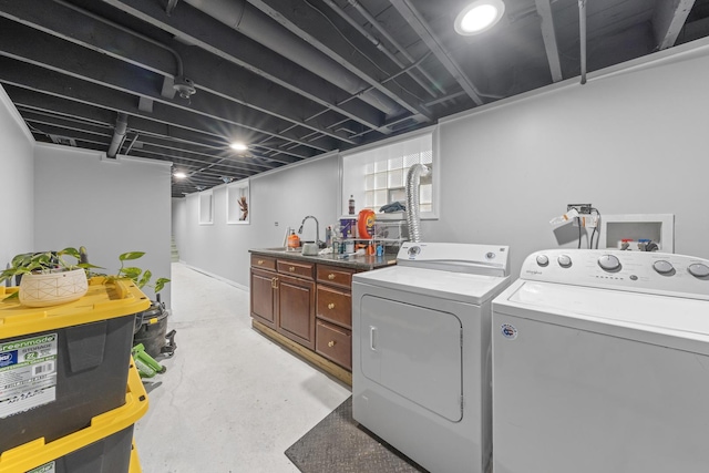 laundry room with cabinets, washing machine and dryer, and sink