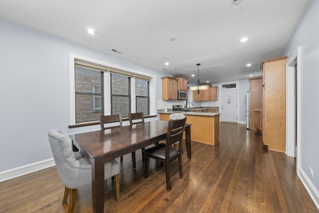 dining area featuring dark wood-type flooring and sink