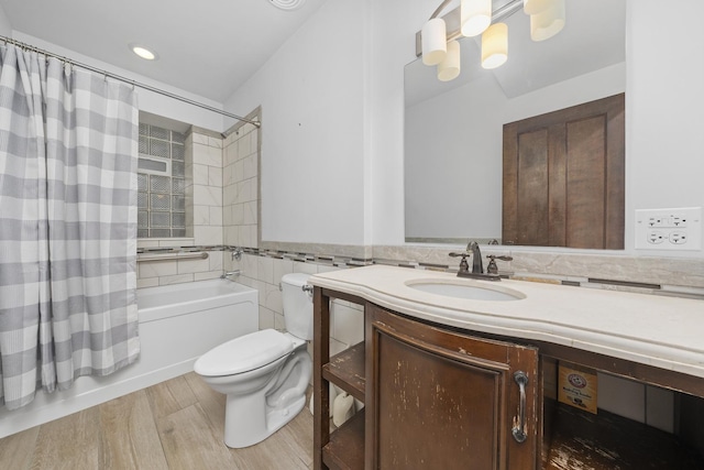 full bathroom featuring vanity, shower / tub combo with curtain, wood-type flooring, tile walls, and toilet