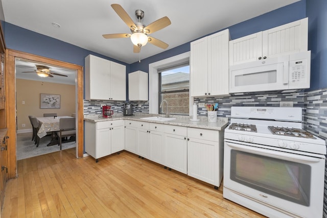 kitchen with white cabinets, white appliances, and sink