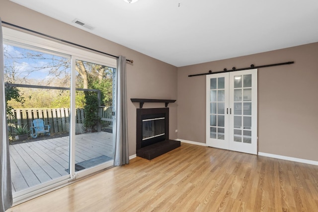 unfurnished living room featuring french doors and light hardwood / wood-style floors