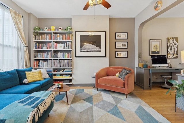 living area with ceiling fan and light hardwood / wood-style floors