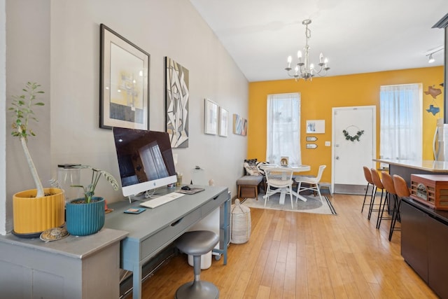 home office featuring a chandelier and light hardwood / wood-style flooring