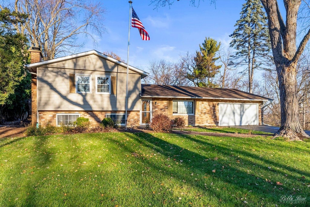 tri-level home featuring a garage and a front yard