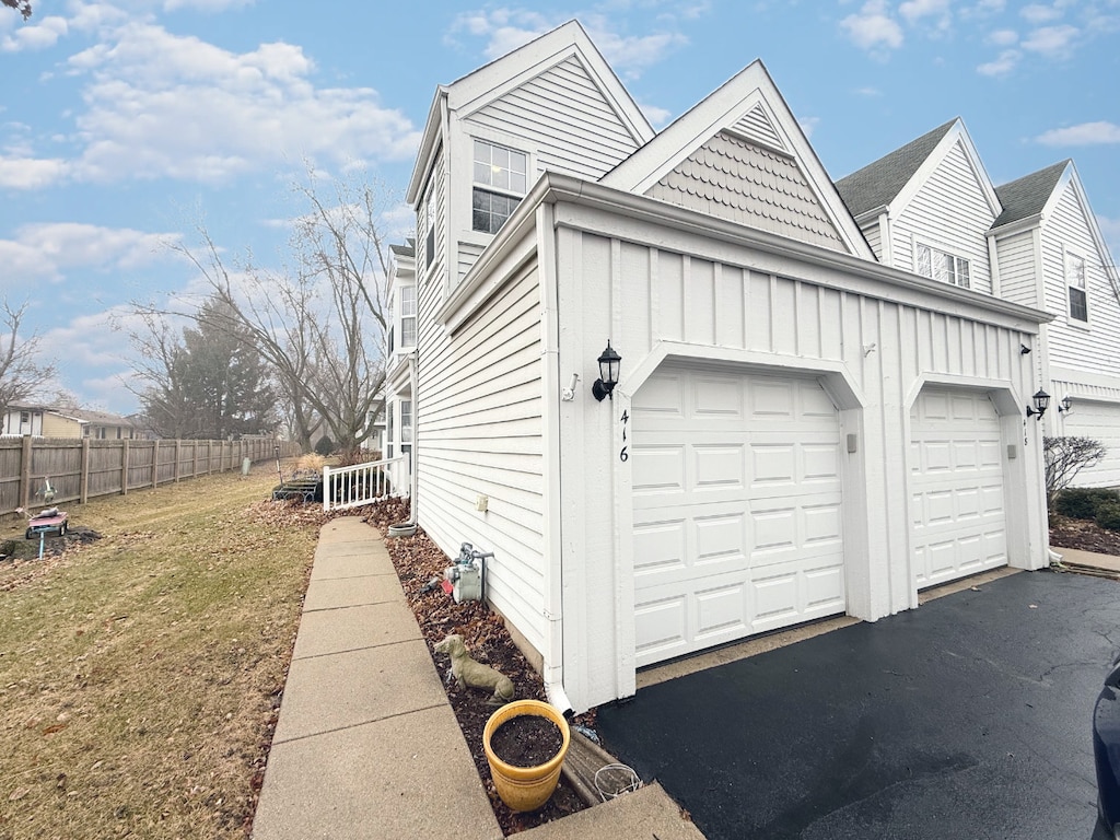 exterior space with a garage and a lawn