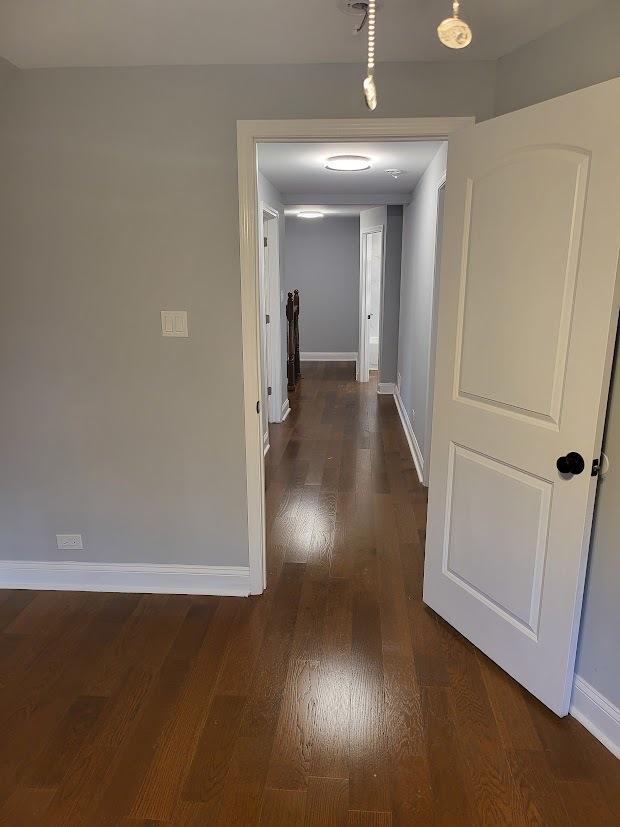 hall featuring dark wood finished floors and baseboards