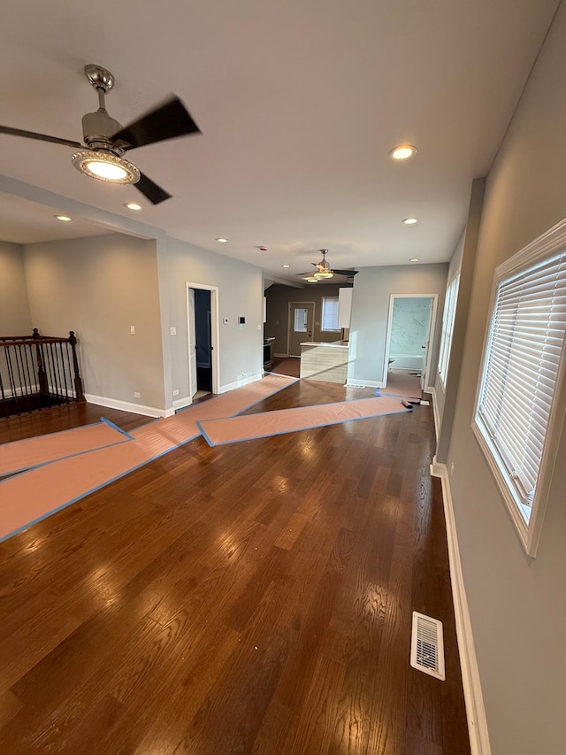 unfurnished living room featuring baseboards, visible vents, ceiling fan, wood finished floors, and recessed lighting