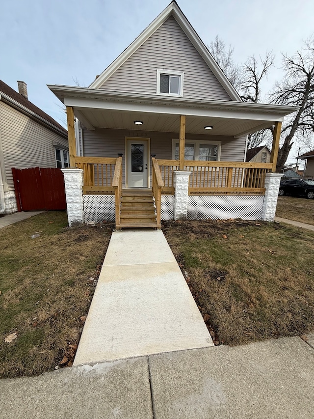 view of front of home with a porch and a front lawn