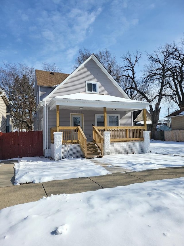 bungalow-style house featuring covered porch and fence