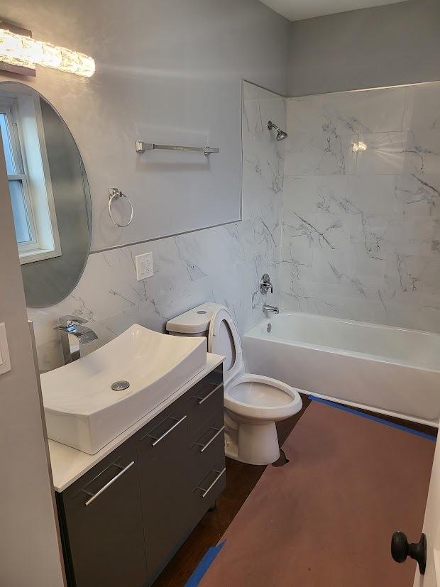 full bathroom featuring vanity, toilet, and tiled shower / bath combo