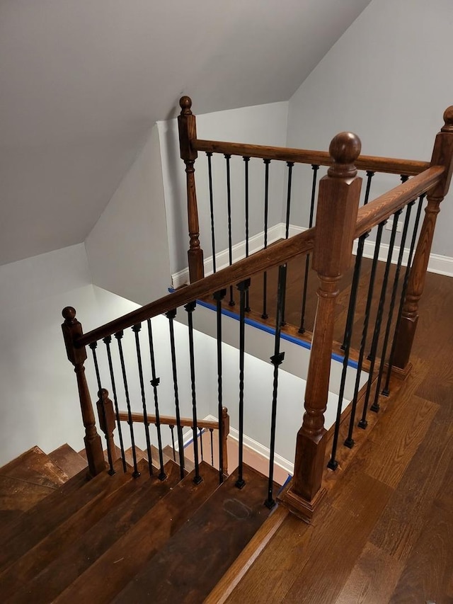 stairway with vaulted ceiling and wood finished floors