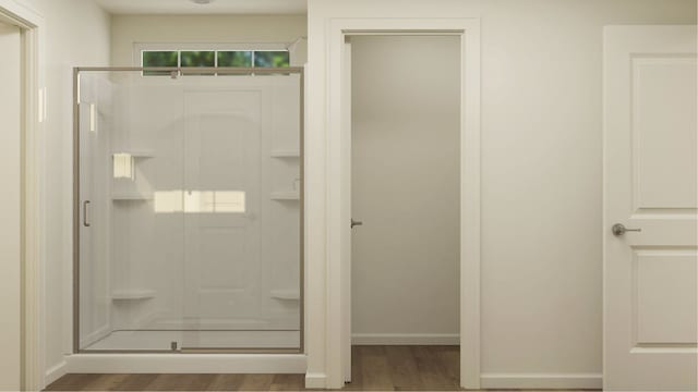 bathroom with wood-type flooring and an enclosed shower