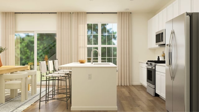 kitchen featuring dark wood-type flooring, a breakfast bar area, a kitchen island, white cabinetry, and stainless steel appliances