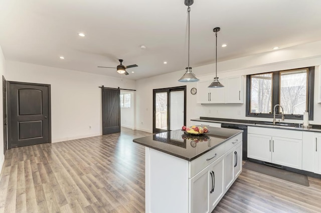 kitchen featuring white cabinets, a barn door, a healthy amount of sunlight, and sink