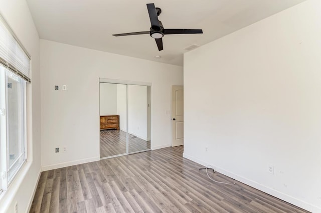 unfurnished bedroom featuring light hardwood / wood-style flooring, a closet, and ceiling fan