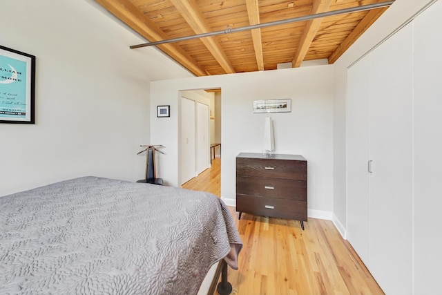 bedroom featuring beamed ceiling, wooden ceiling, and light wood-type flooring