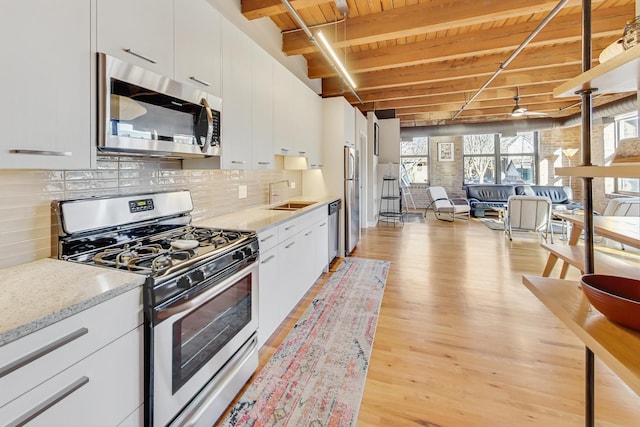 kitchen with sink, white cabinets, stainless steel appliances, wooden ceiling, and light wood-type flooring