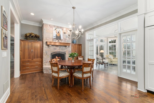 dining space with a notable chandelier, dark wood-type flooring, a fireplace, and ornamental molding